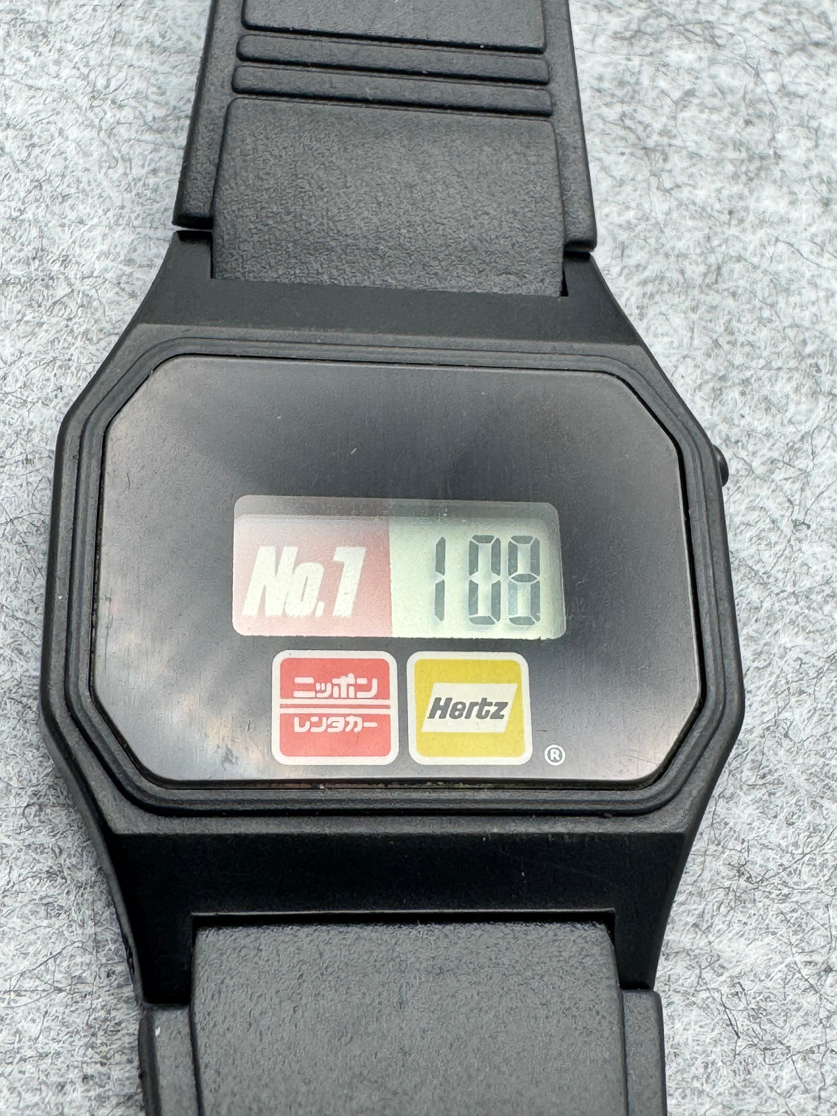 Montre publicitaire Nippon Rent-A-Car / Hertz – montre numérique japonaise issue d'une campagne de coopération – révisée