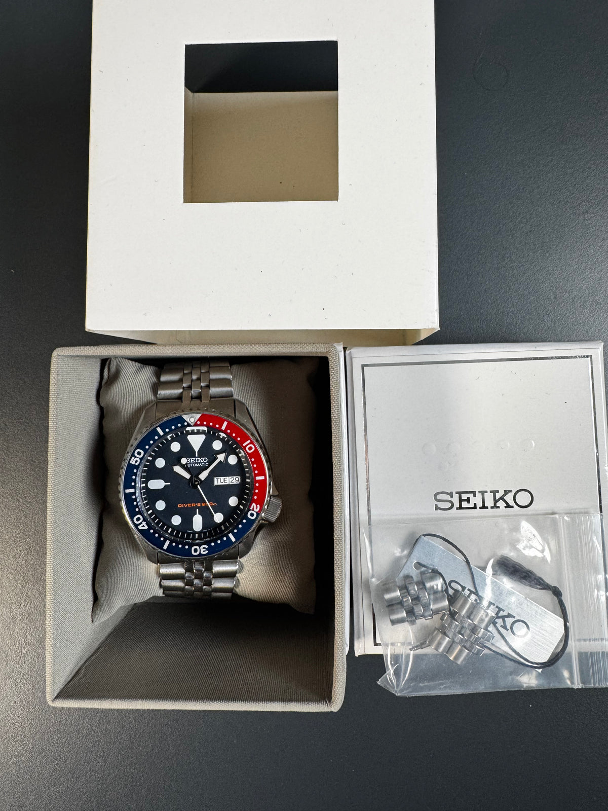 Seiko SKX009K2 Pepsi – in der Seiko-Box mit Umkarton, Anhänger und Ersatzgliedern
